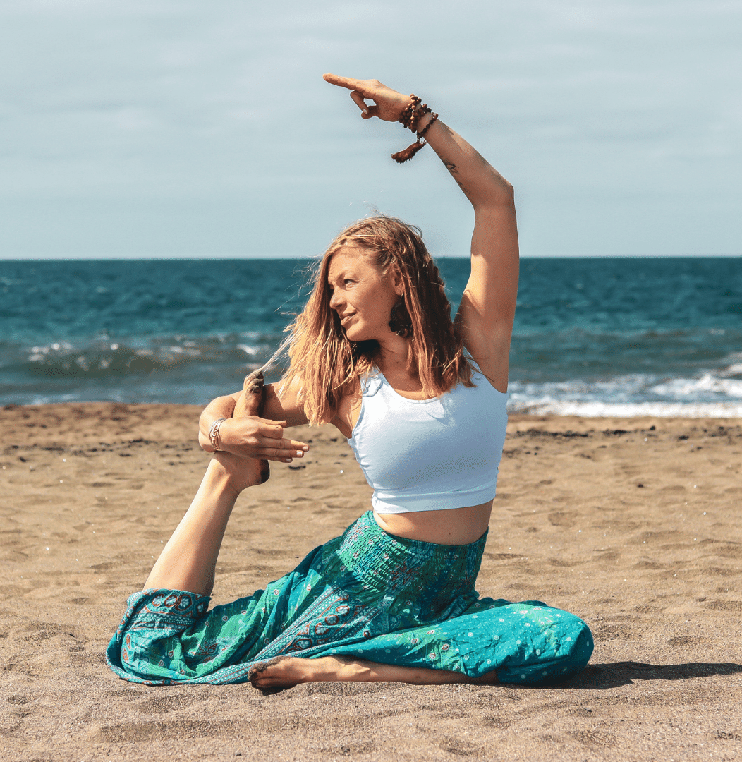 Woman-on-the-beach-with-open-hair-in-Yogapose-Kapotasana-with-sea-in-the-background